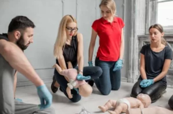 Instructor teaching CPR to a family in their living room.