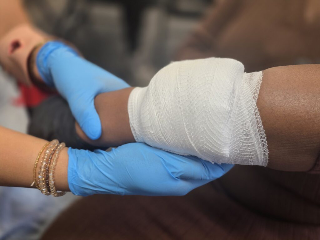 Students practicing bandaging in one of our CPR and first aid courses
